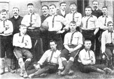 A vintage black and white photo of a men's sports team posing together.