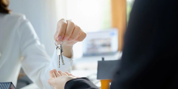 Person handing house keys to another person