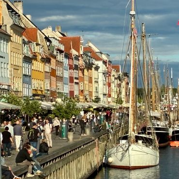 Colorful waterfront with boats and people.