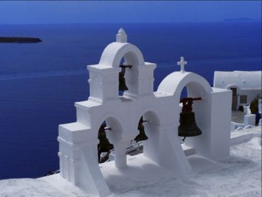 White bell tower by the sea in Santorini.