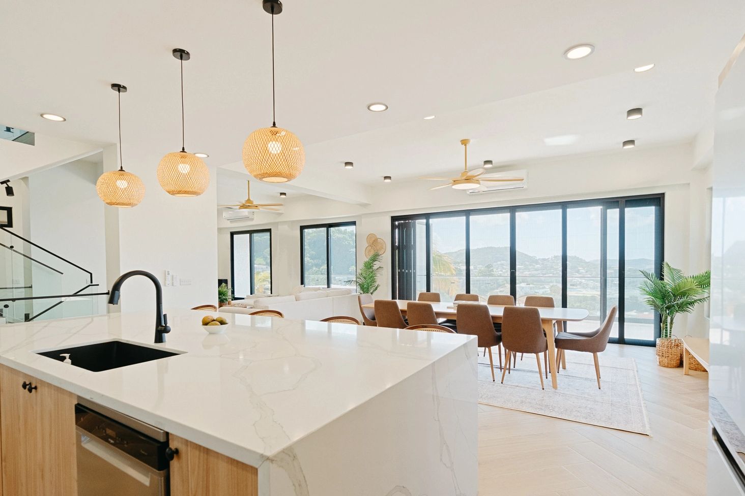 Modern kitchen and dining area with natural light and scenic views.