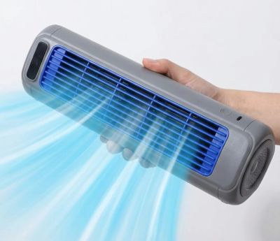 Handheld portable fan blowing cool air.