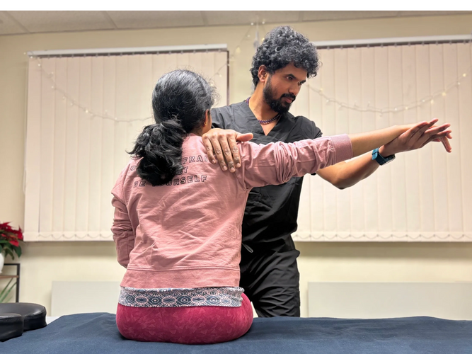 Physio at C7 CFSE.uk in Stirling assessing a patient’s shoulder joint for pain, mobility, & injury.