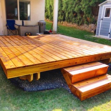 Newly built wooden deck with small steps in a backyard.