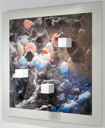 Abstract wall art with colorful textured patterns and three white cubes.