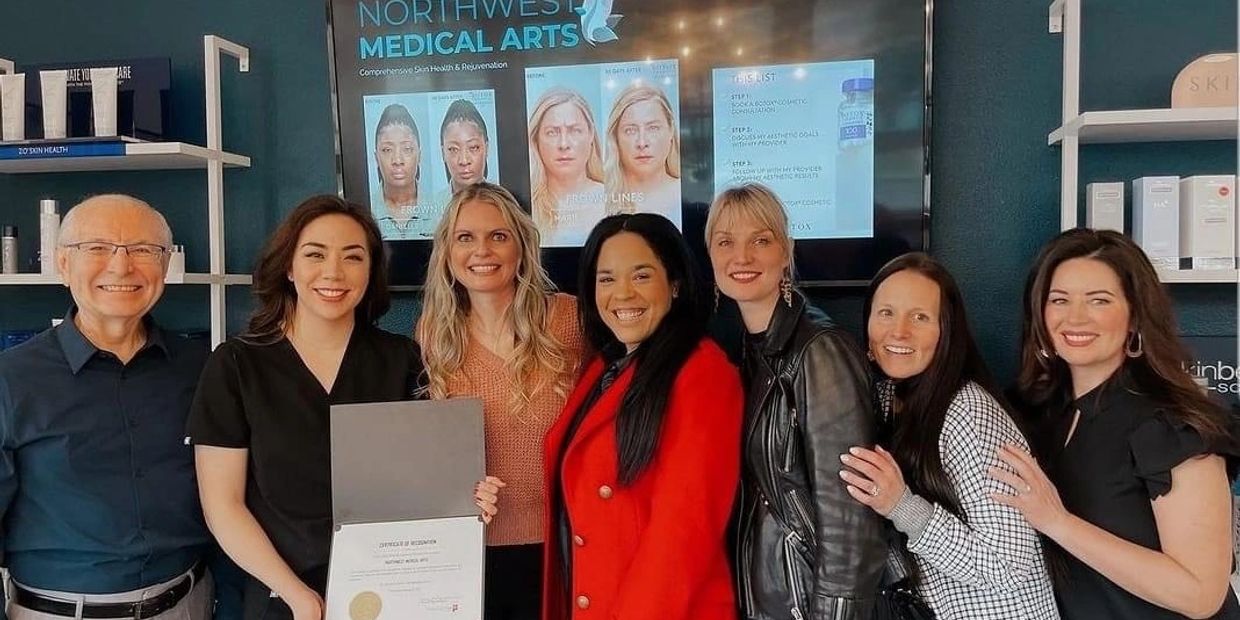 Group photo of smiling medical professionals celebrating a certificate achievement.
