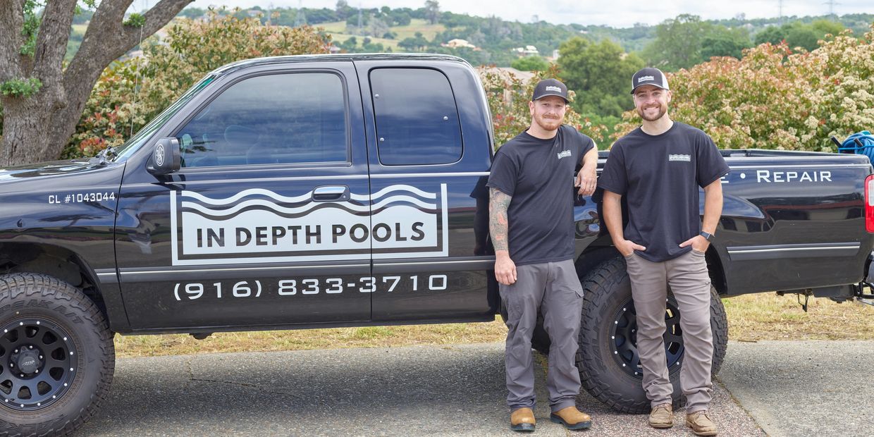The owner and repair technician standing next to work truck.
