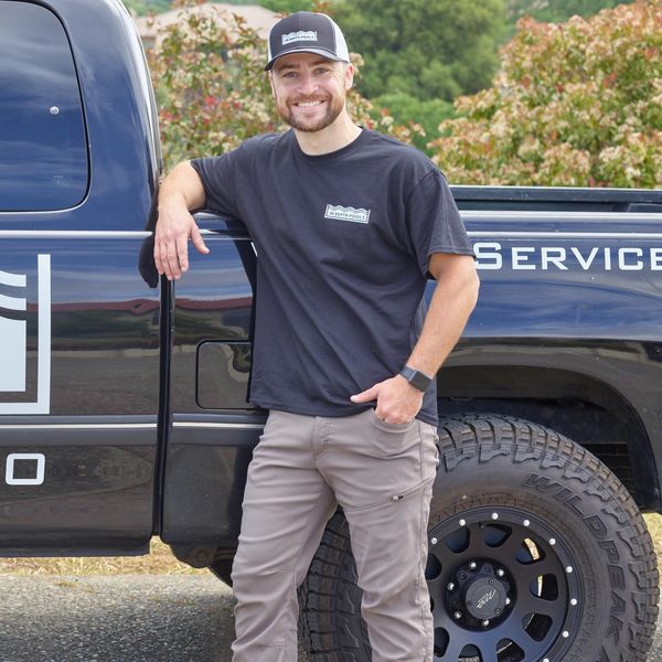 Owner standing happily next to pool repair truck