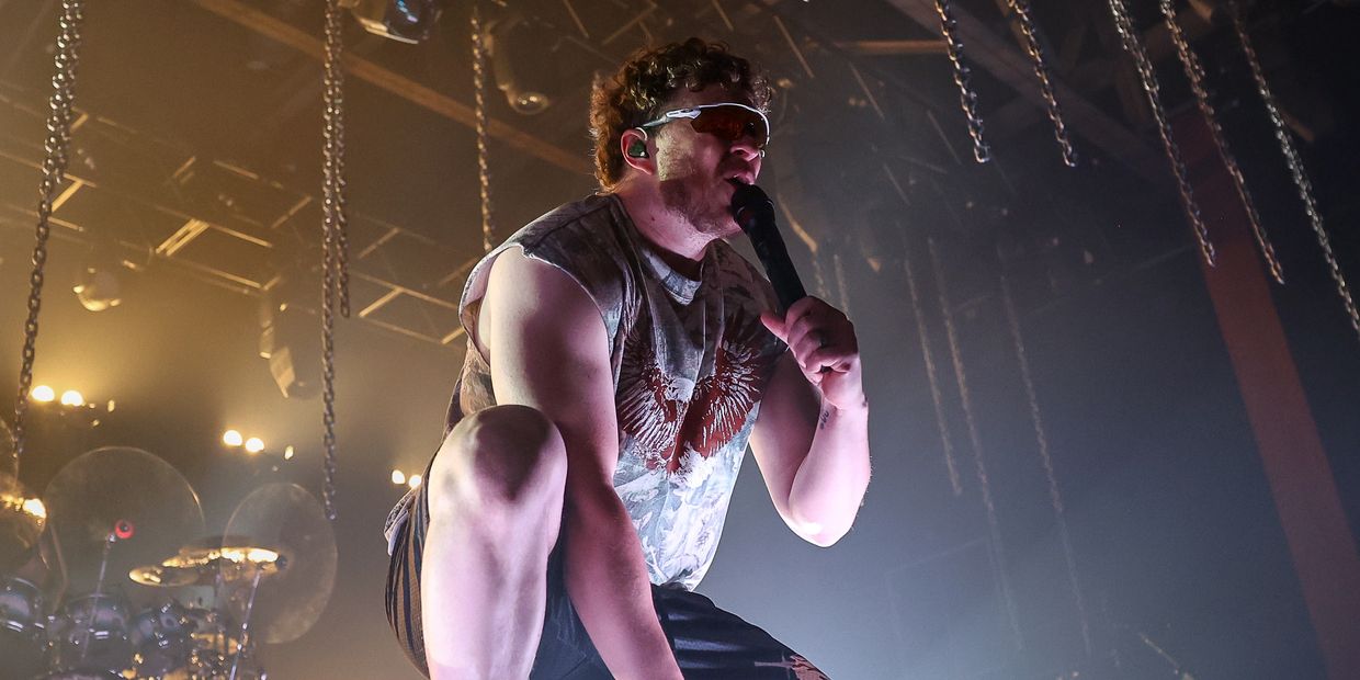 Male singer performing energetically on stage.