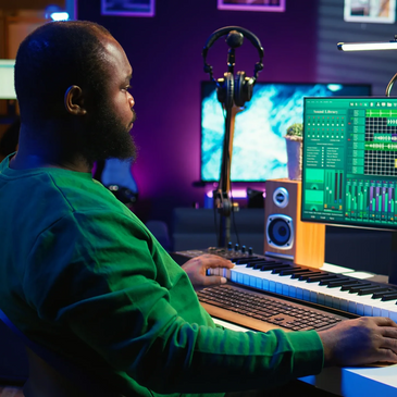 Man working on music production with MIDI keyboard and audio software.