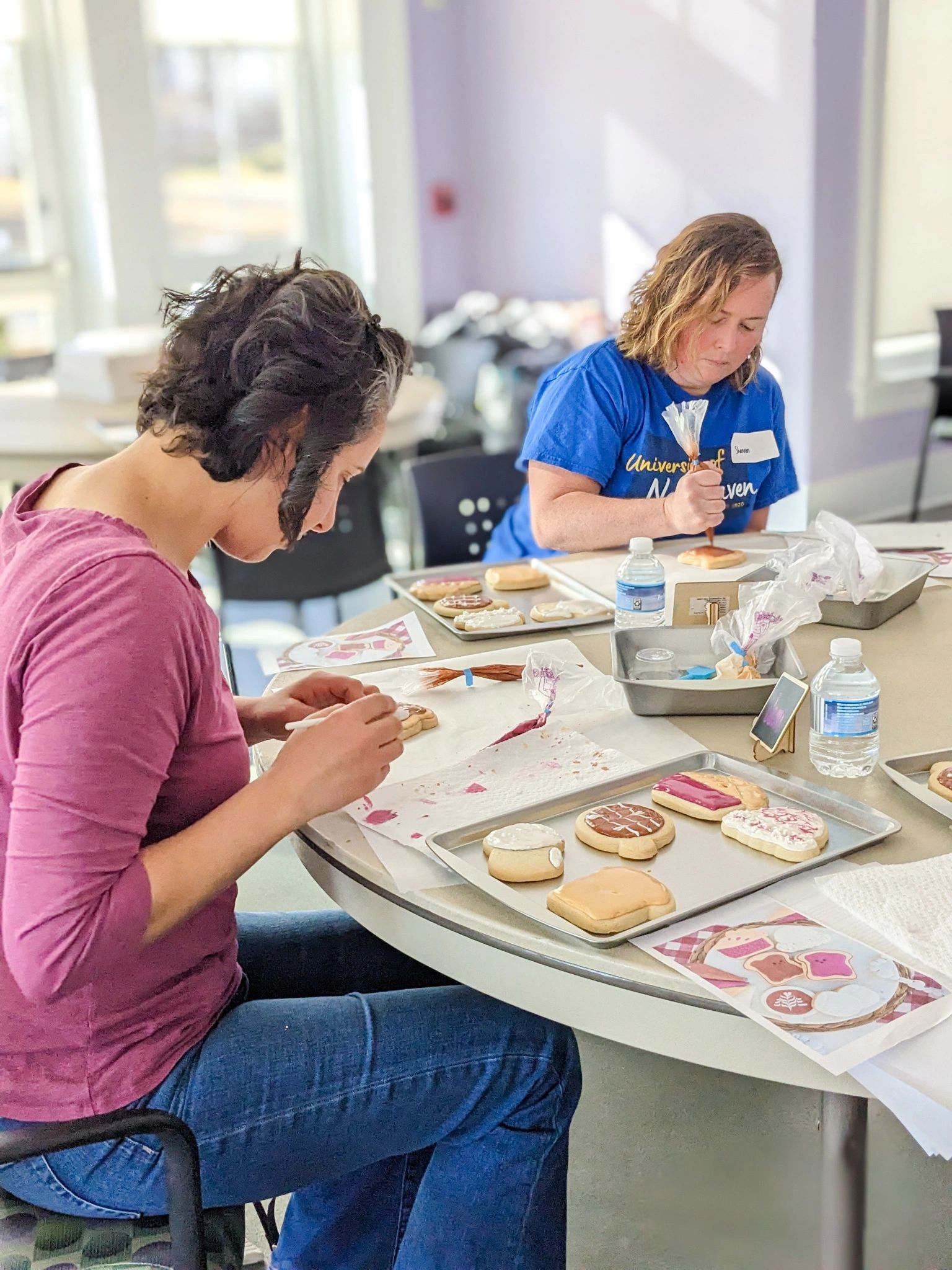 Two cookie class participants decorating their Valentine's day sugar cookies 