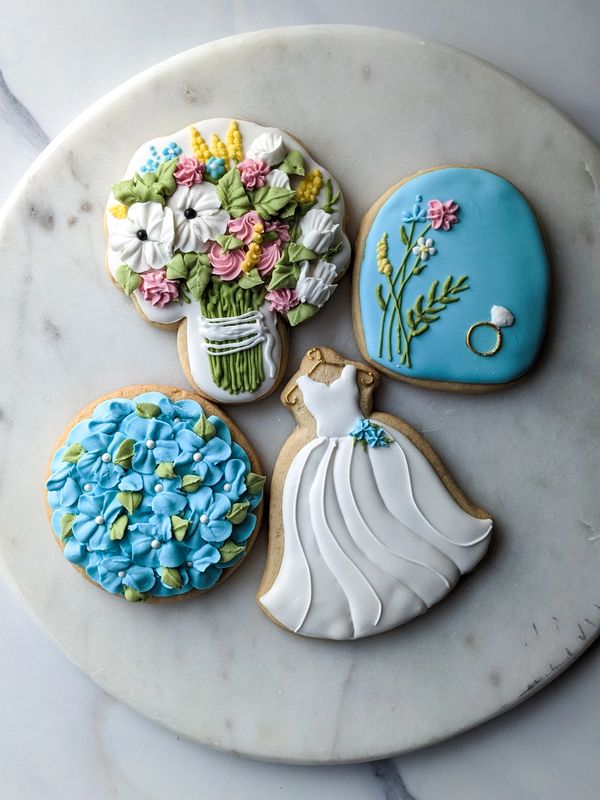 Bridal shower cookies including a gown, ring, bouquet, and hydrangeas