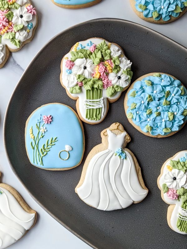 Bridal shower cookies including a gown, ring, bouquet, and hydrangeas