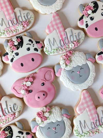 Sugar cookies shaped like cows, sheep, pigs, and a gingham number one with "Maddie" 