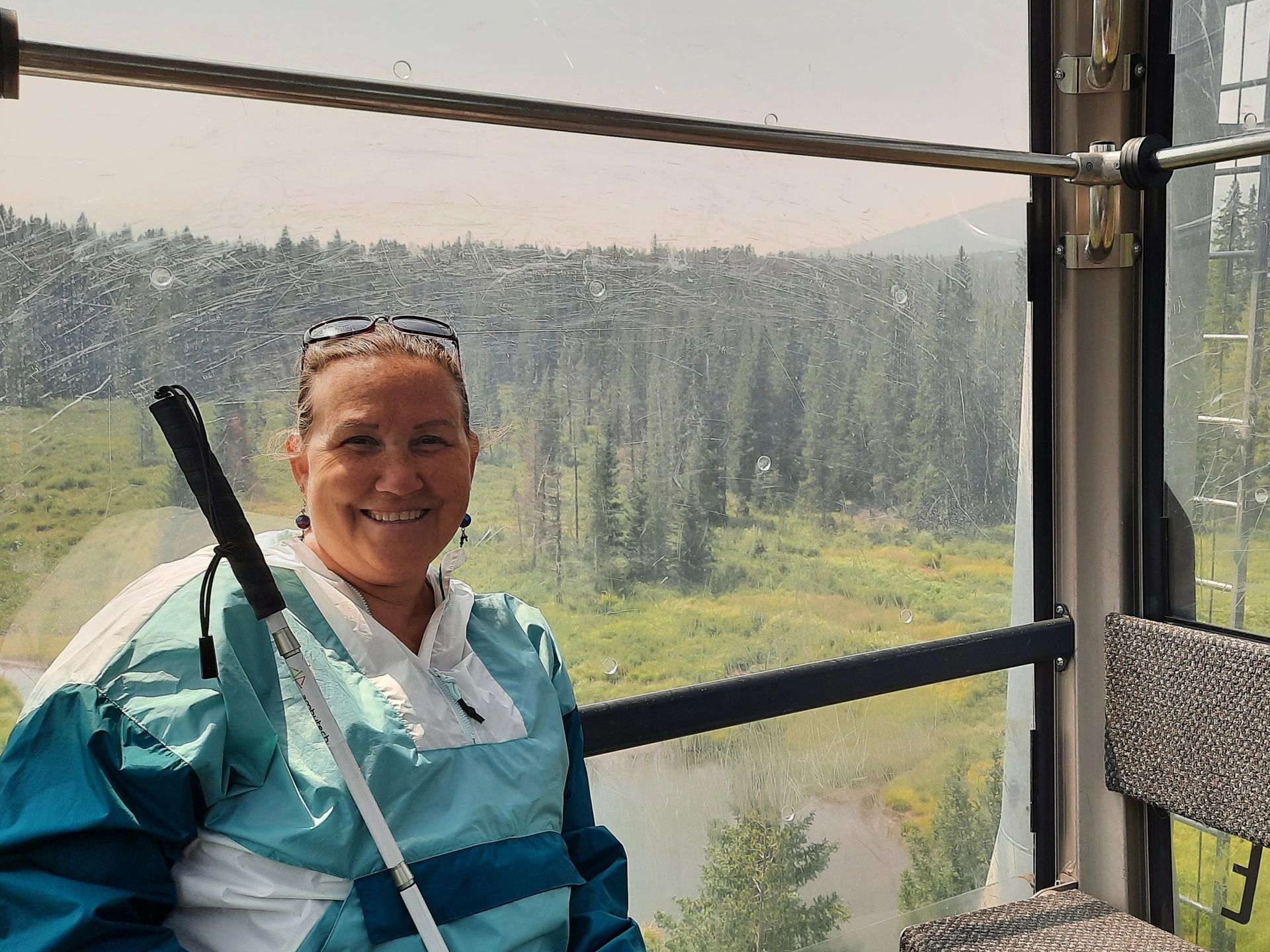 Me with my white cane riding the gondola at Winter Park Ski Resort, CO, in the fall.