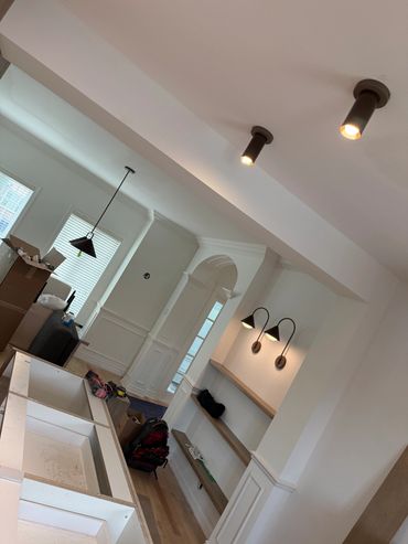 Cuisine en rénovation avec nouvelles lumières et étagères.