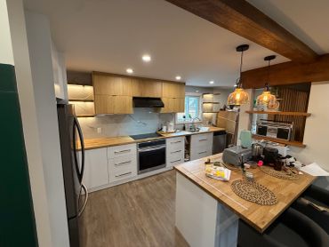 Cuisine moderne avec îlot central en bois et appareils électroménagers inox.