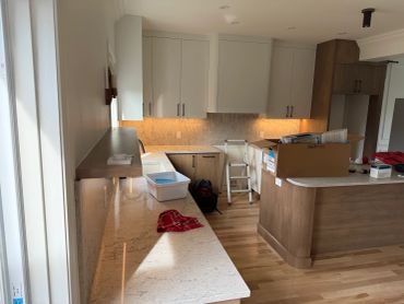 Cuisine moderne avec plans de travail en quartz et parquet.