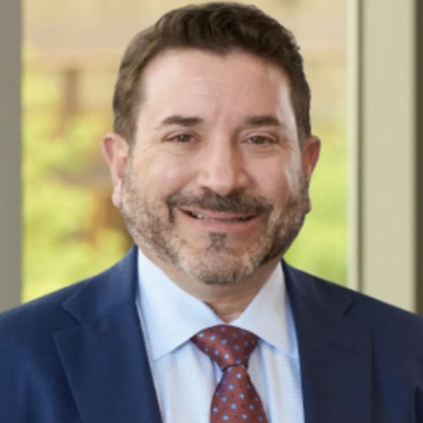 Man in suit smiling at the camera.