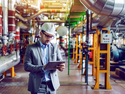 Engineer using tablet in industrial facility.






