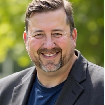 Smiling man with beard in blazer outdoors.