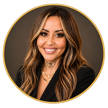 Smiling woman with highlighted hair and tattoo, wearing black blazer.