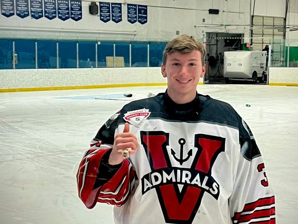Hockey player in Admirals jersey celebrating victory on ice rink.