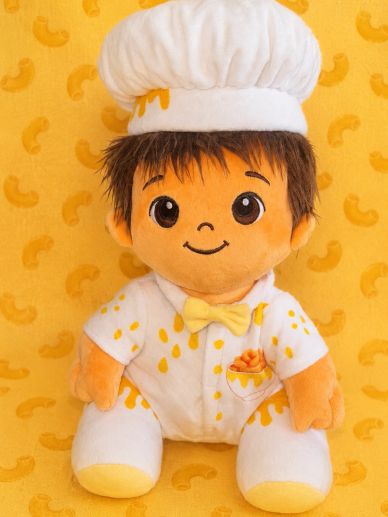 Cute plush doll dressed as a chef with macaroni-themed outfit.