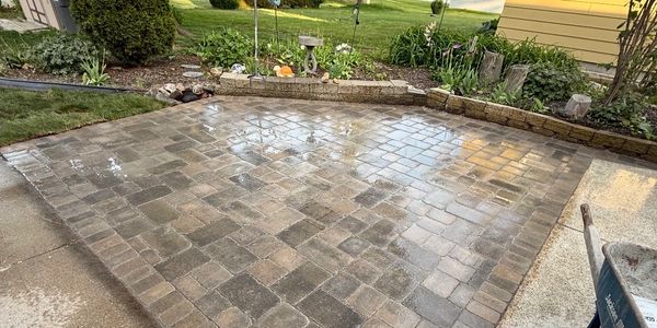 Wet stone patio with surrounding garden and lawn.
