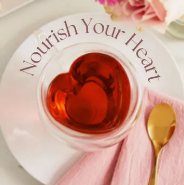 Heart-shaped tea with 'Nourish Your Heart' text on a white plate.