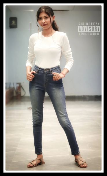 Young woman posing confidently in casual outfit indoors.
