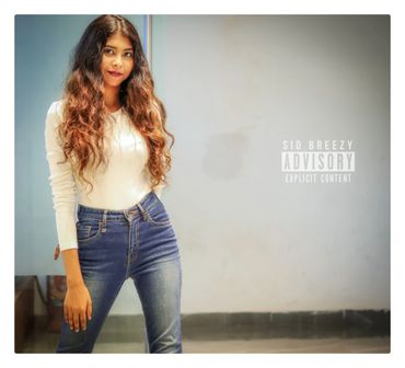 Young woman with long hair posing against a plain wall.