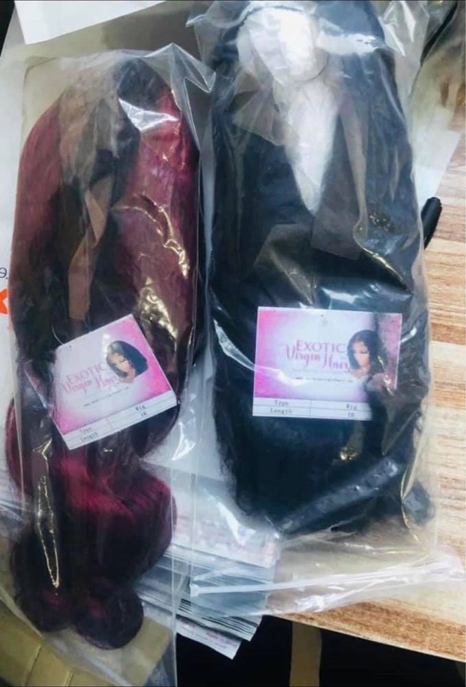 Two packaged hair extensions labeled Exotic Virgin Hair in black and burgundy colors.