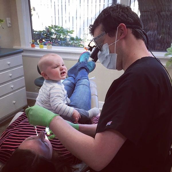 Dr. Williams providing dental care to his wife, while his son watches on