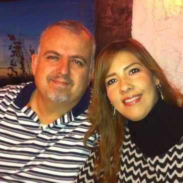 A smiling couple posing closely together.