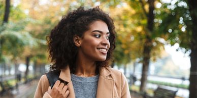 Smiling woman looking to her left, feeling hopeful and confident.