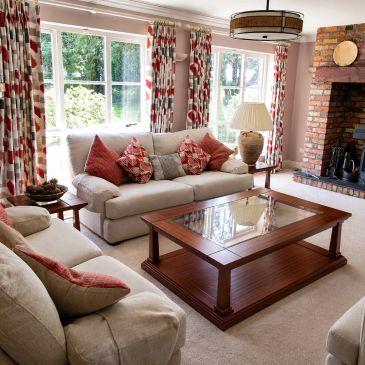 Cozy living room with beige sofas and red accents.