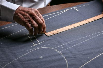 Hand drawing measurements on fabric with a ruler.