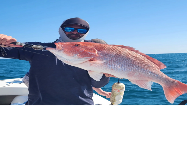 client holding Redsnapper he caught deep sea fishing