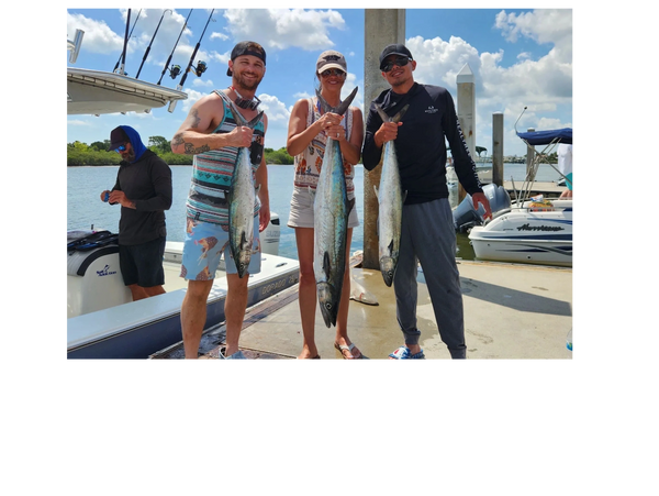 clients holding kingfish they caught while deep sea fishing