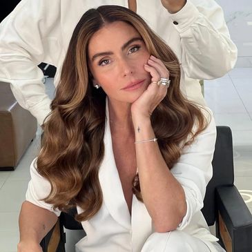 Mulher com cabelo ondulado e roupa branca.