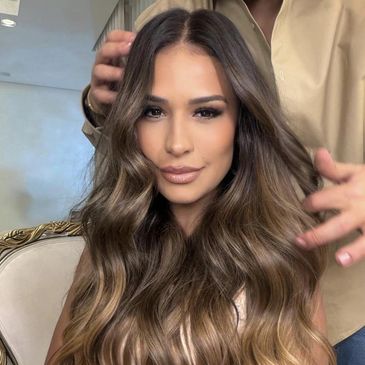 Mulher com cabelo longo e ondulado sendo penteada.