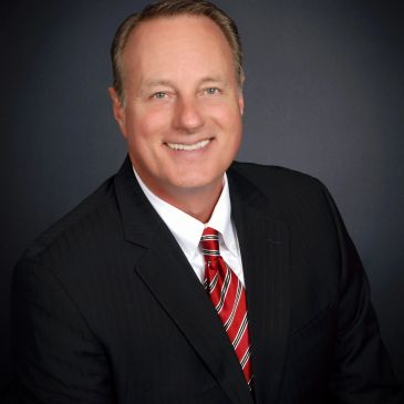 Smiling man in a suit and striped tie.