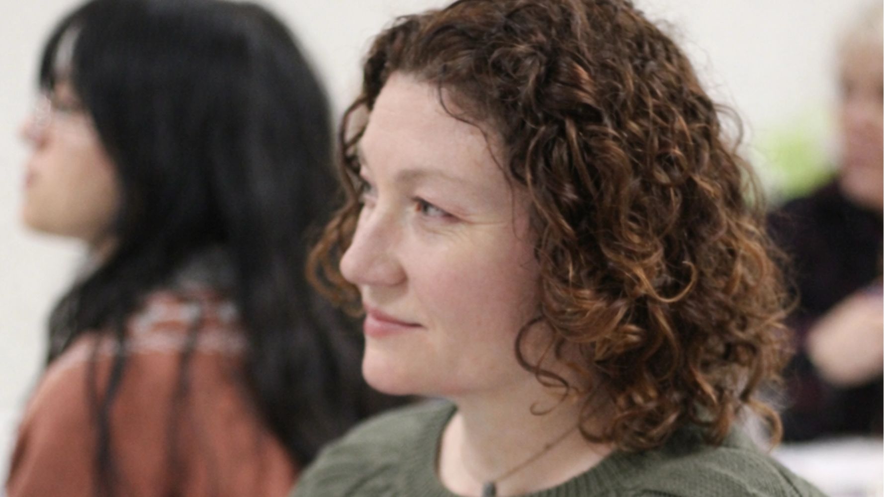 Stack of books next to pencils in a holder and a camera.
