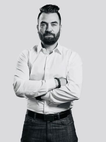Man with beard and crossed arms.