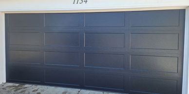 A black long recessed panel garage door custom made for a customer