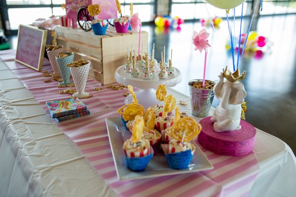 carnival theme baby shower table set-up including cake pops, and funnel cakes on a stick