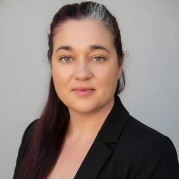 Professional portrait of a woman in a black blazer and white top.