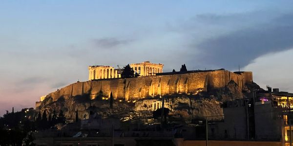 Illuminated Acropolis at dusk in Athens.