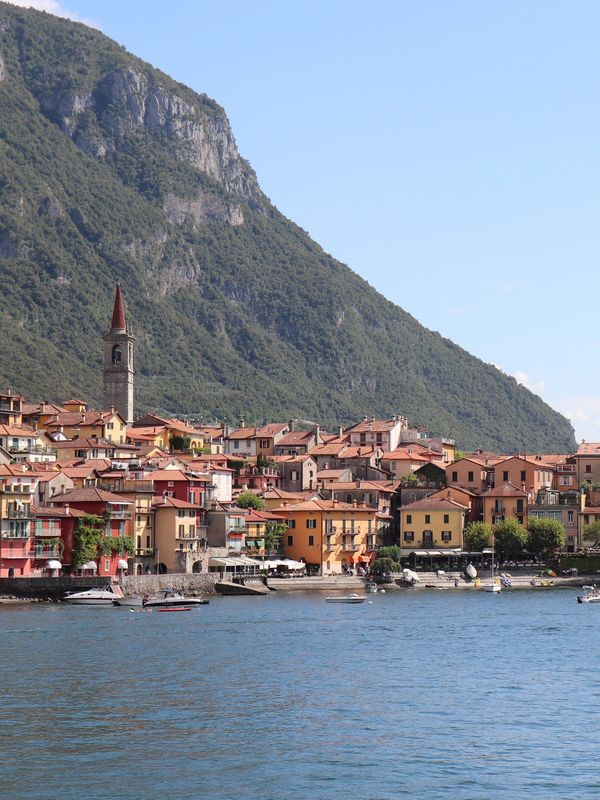 Colorful lakeside village with mountain backdrop.